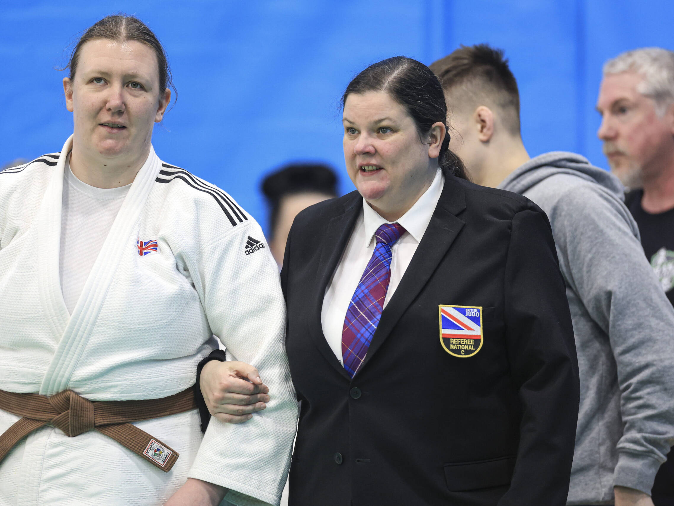 Kirsten Taylor being led to the mat by referee