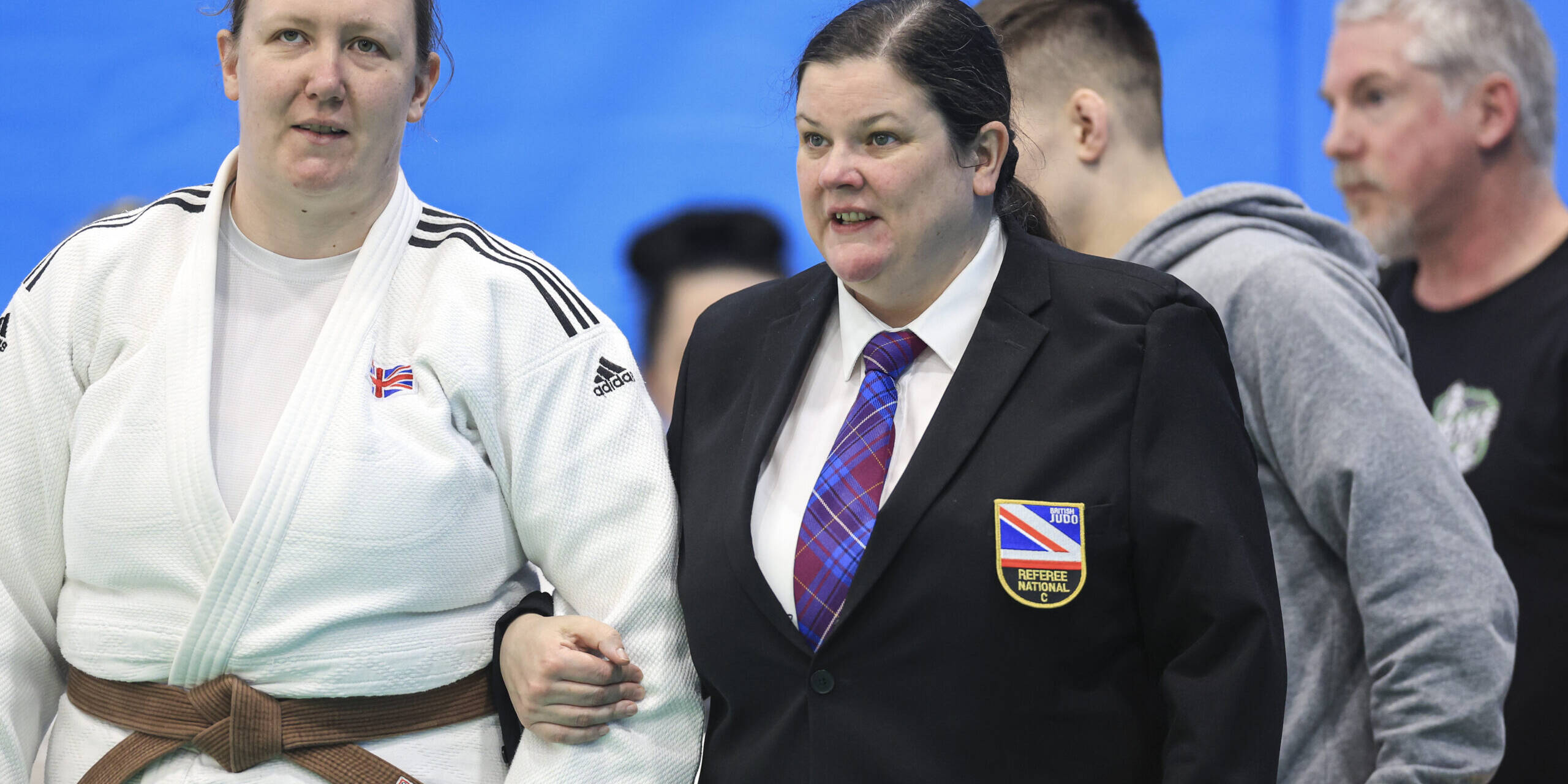 Kirsten Taylor being led to the mat by referee