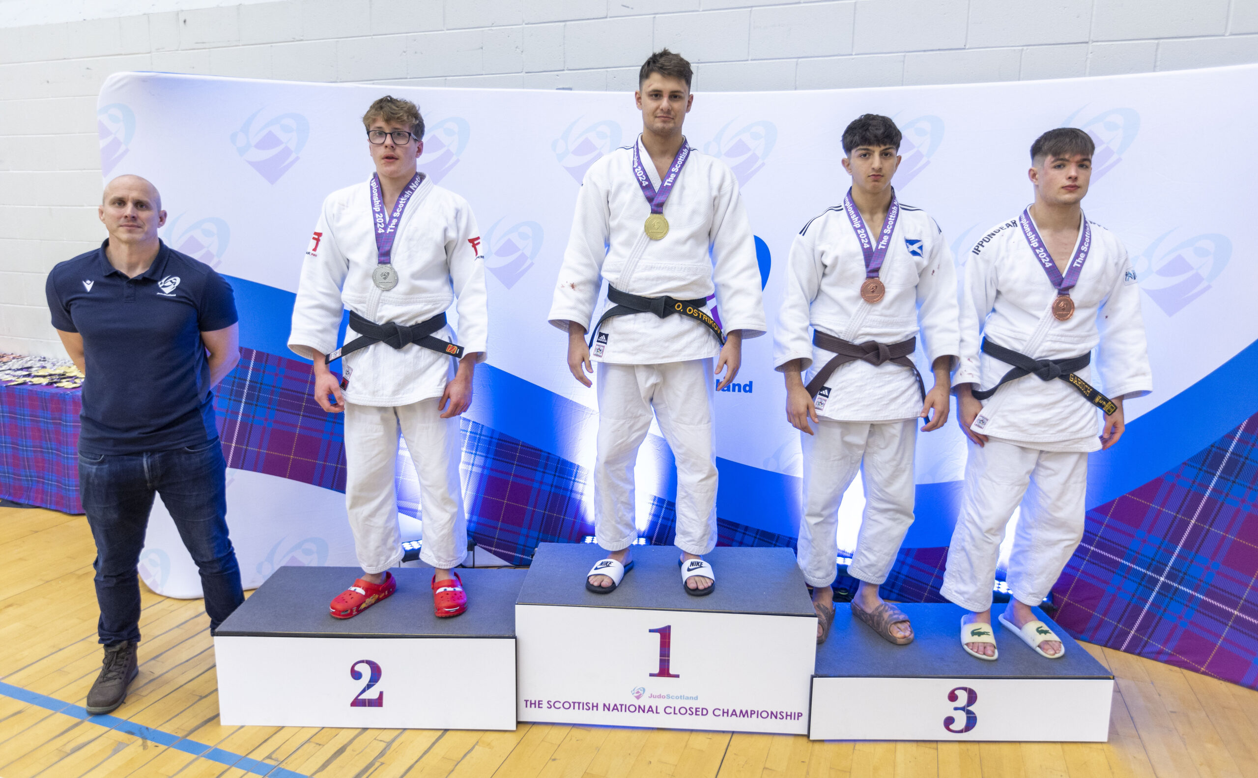 Oleksandr Ostitov standing on the podium with his fellow medal winners.