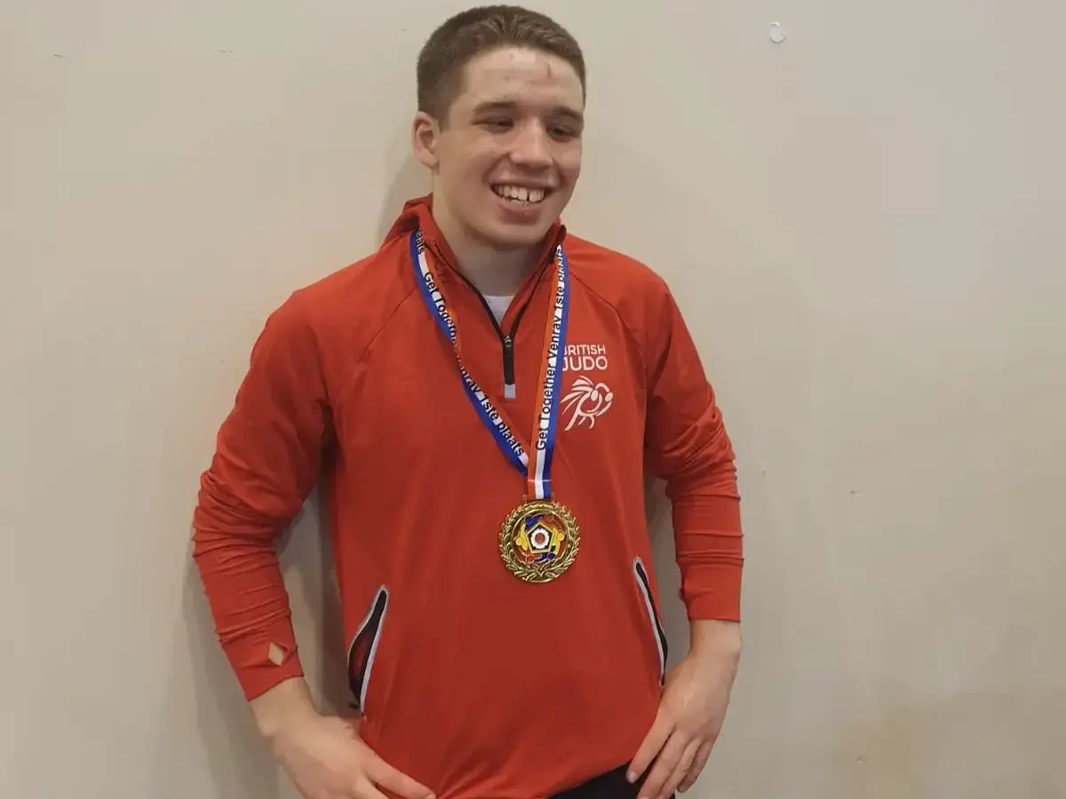 Murray McConnell proudly shows off his medal wearing his GB tracksuit